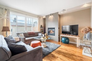 Ein modernes Wohnzimmer mit einer Couch, einem Couchtisch und einem Flachbildfernseher.