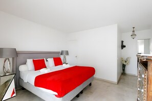 A hotel room with a bed, bedside tables, a mirror, a dresser, and a chandelier. - Apartment '3 Pièces Cannes' with Shared Terrace, Wi-Fi and Air Conditioning (Cannes)