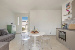 Eine moderne Küche mit Essbereich, einem grünen Schrank und Blick ins Freie.