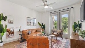 A living room with a sofa, armchairs, a coffee table, and a ceiling fan. - Comfortable 1BR Retreat at The Nelson TNS 5205 (Austin)