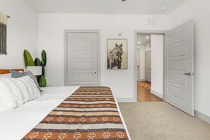 Ein Schlafzimmer mit einem Bett, einem Teppich und einer Tür zu einem anderen Raum.