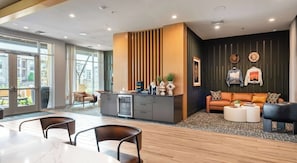A modern living room with a sofa, coffee table, and a dining area with chairs and a table. - Relaxed 1BR Apartment Stay at The Nelson TNS 4204 (Austin)