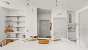 A modern kitchen with a central island, white cabinetry, and pendant lighting. - Relaxed 1BR Apartment Stay at The Nelson TNS 4204 (Austin)
