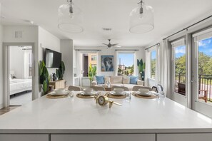 A spacious kitchen with a central island, large windows, and a ceiling fan. - Stylish 2BR Apartment for Work & Relaxing TNS 4202 (Austin)