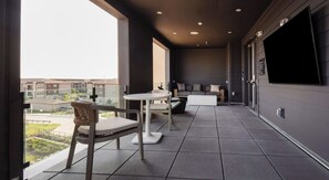 A modern balcony with a view of buildings, a sofa, a table, and a chair. - Stylish 2BR Apartment for Work & Relaxing TNS 4202 (Austin)