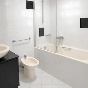 Ein modernes Badezimmer mit einer Badewanne, einem Bidet und einem Waschtisch.
