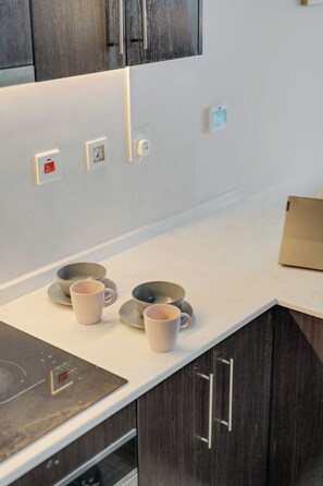A kitchen with a white countertop, a coffee maker, and a box on the counter. - Beautiful Dubai Marina View 1BR - Walk to Beach & Metro (Dubai)