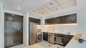 A modern kitchen with stainless steel appliances, a built-in oven, and a dishwasher. - Beautiful Dubai Marina View 1BR - Walk to Beach & Metro (Dubai)