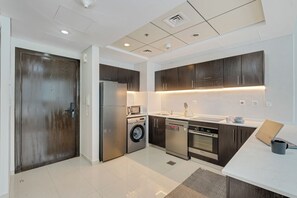 A modern kitchen with stainless steel appliances, a built-in oven, and a dishwasher. - Beautiful Dubai Marina View 1BR - Walk to Beach & Metro (Dubai)