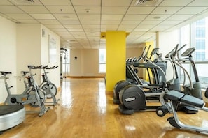 A gym with cardio equipment, including treadmills and stationary bikes, and a wooden floor. - Beautiful Dubai Marina View 1BR - Walk to Beach & Metro (Dubai)