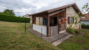 Un piccolo edificio rustico con un portico, una finestra e una porta.