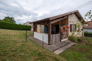 A small, rustic building with a porch, a window, and a door.