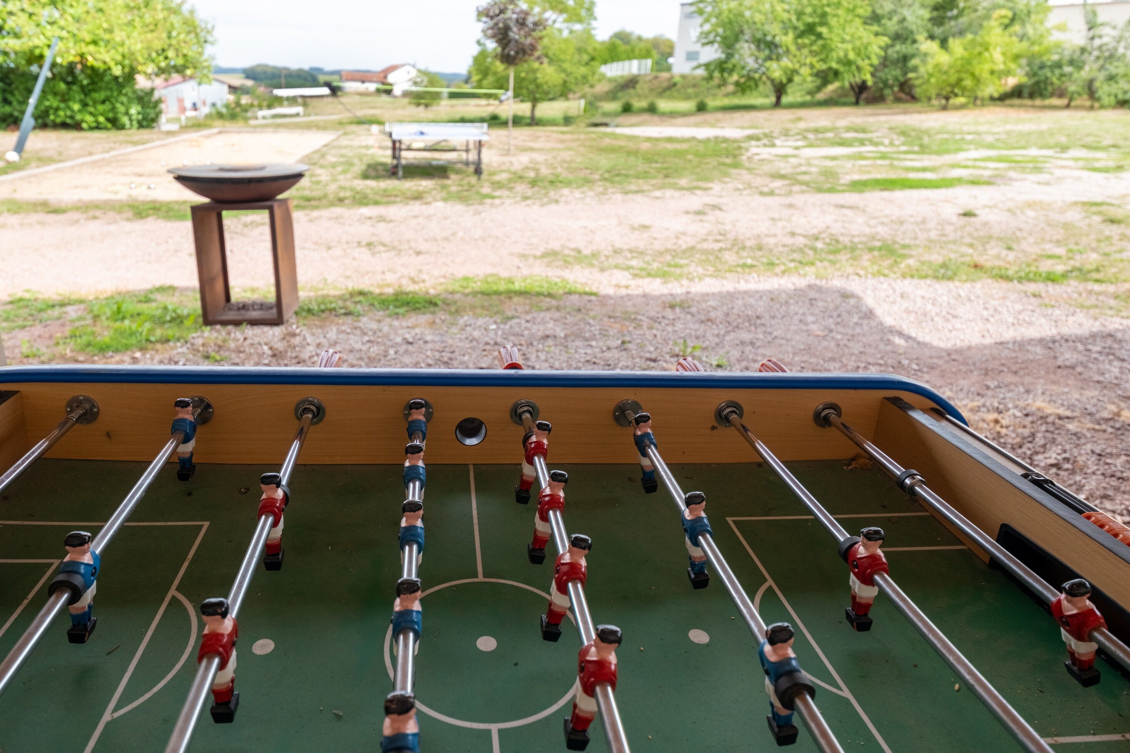 Une table de baby-foot avec des joueurs portant des maillots rouges et bleus.