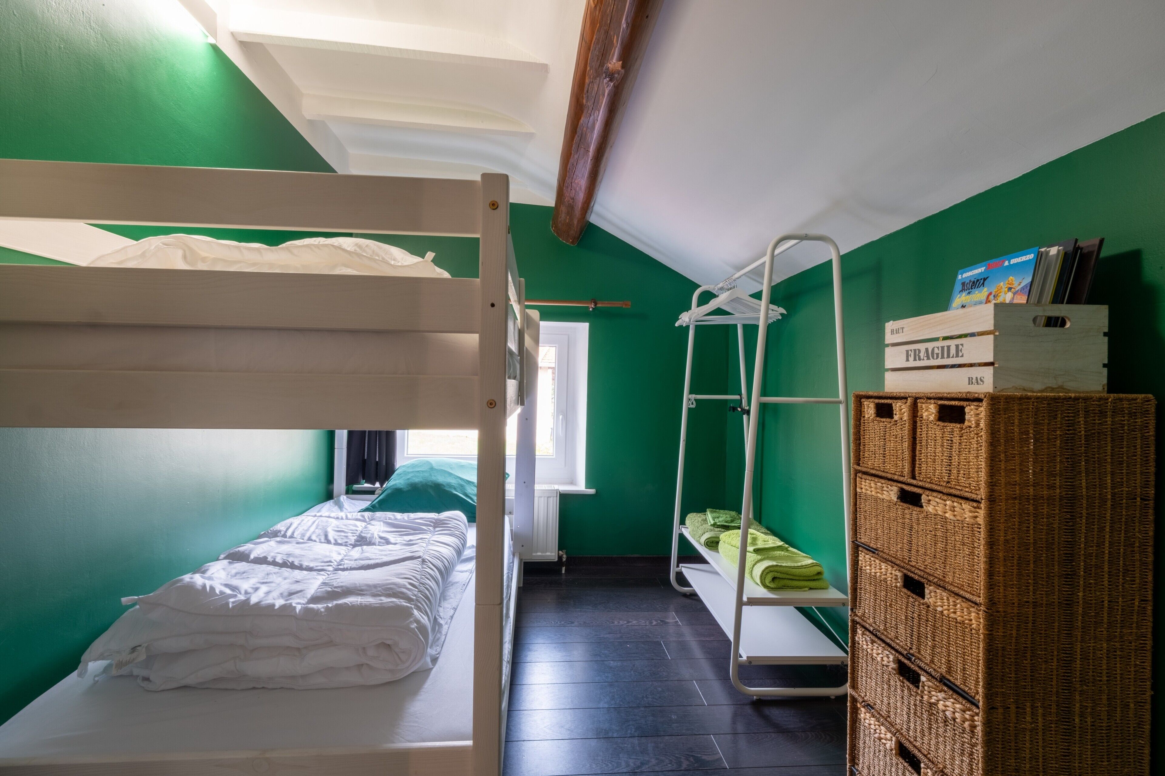 A small, compact room with bunk beds, a drying rack, and a storage unit.