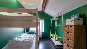 A small, compact room with bunk beds, a drying rack, and a storage unit.