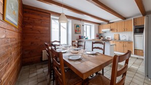A wooden interior with a dining table set for six, kitchen cabinets, and a refrigerator. - La Grande Escapade Holiday Home – 6 Guests (Up to 10 on Request), Countryside View, Terrace, Wi-Fi (Xertigny)