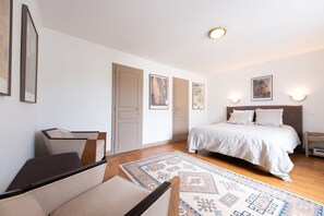 A bedroom with a bed, a desk, a chair, and a rug.
