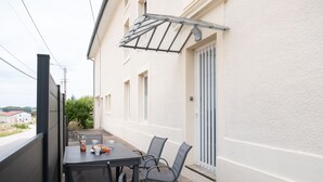 An outdoor dining area with a table and chairs, a bottle of juice, and a glass of orange juice. - La Grande Escapade Holiday Home – 6 Guests (Up to 10 on Request), Countryside View, Terrace, Wi-Fi (Xertigny)