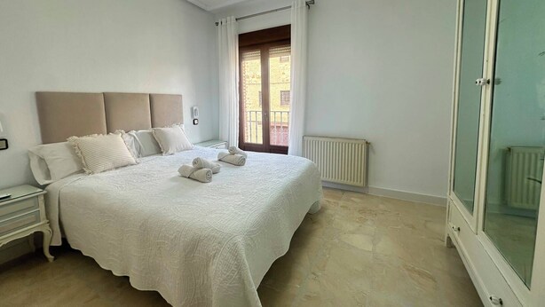 A bedroom with a bed, nightstand, and a wardrobe.