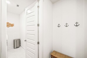 A white interior with a door, a trash bin, and wall-mounted anchors. - A/C Game room, Golf Cart,  Autism Friendly (Port St Joe)