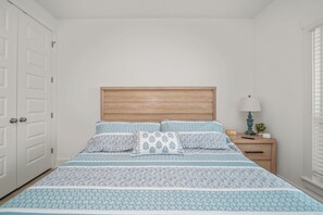 A bedroom with a bed, a wooden headboard, a bedside table with a lamp, and a clock. - A/C Game room, Golf Cart,  Autism Friendly (Port St Joe)