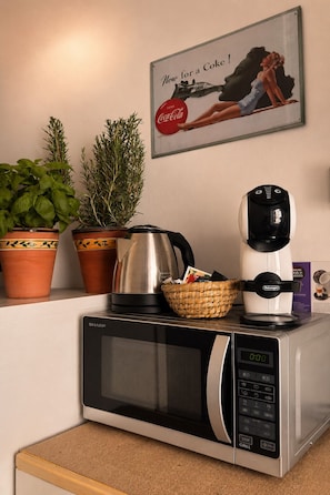 A kitchen with a microwave, a coffee maker, a kettle, and two potted plants on the counter. - Just a short walk from the Cathedral, the Swabian Castle, the harbor, and downtown. (Trani)
