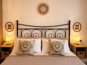 A neatly made bed with a metal headboard, two bedside lamps, and decorative pillows. - Just a short walk from the Cathedral, the Swabian Castle, the harbor, and downtown. (Trani)
