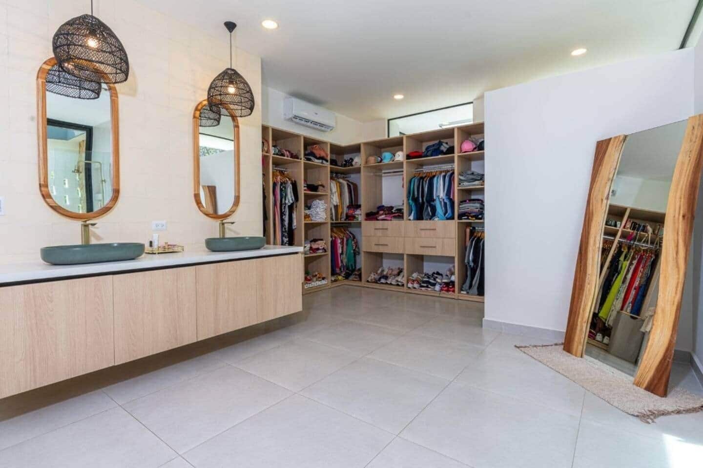 A modern bathroom with a large vanity, two mirrors, and a sink.