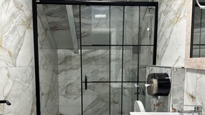 Ein Badezimmer mit Duschkabine, Toilette und Waschbecken.