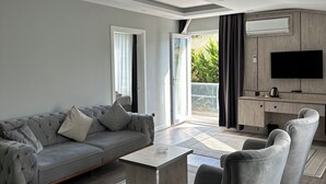 Ein modernes Wohnzimmer mit einem grauen Sofa, einem Couchtisch und zwei Sesseln.
