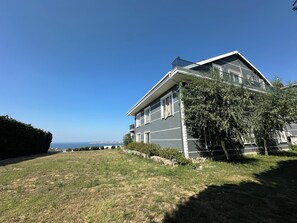 A two-story house with a clear view of the ocean in the background. - Sunset Hill Hotel (İstanbul)