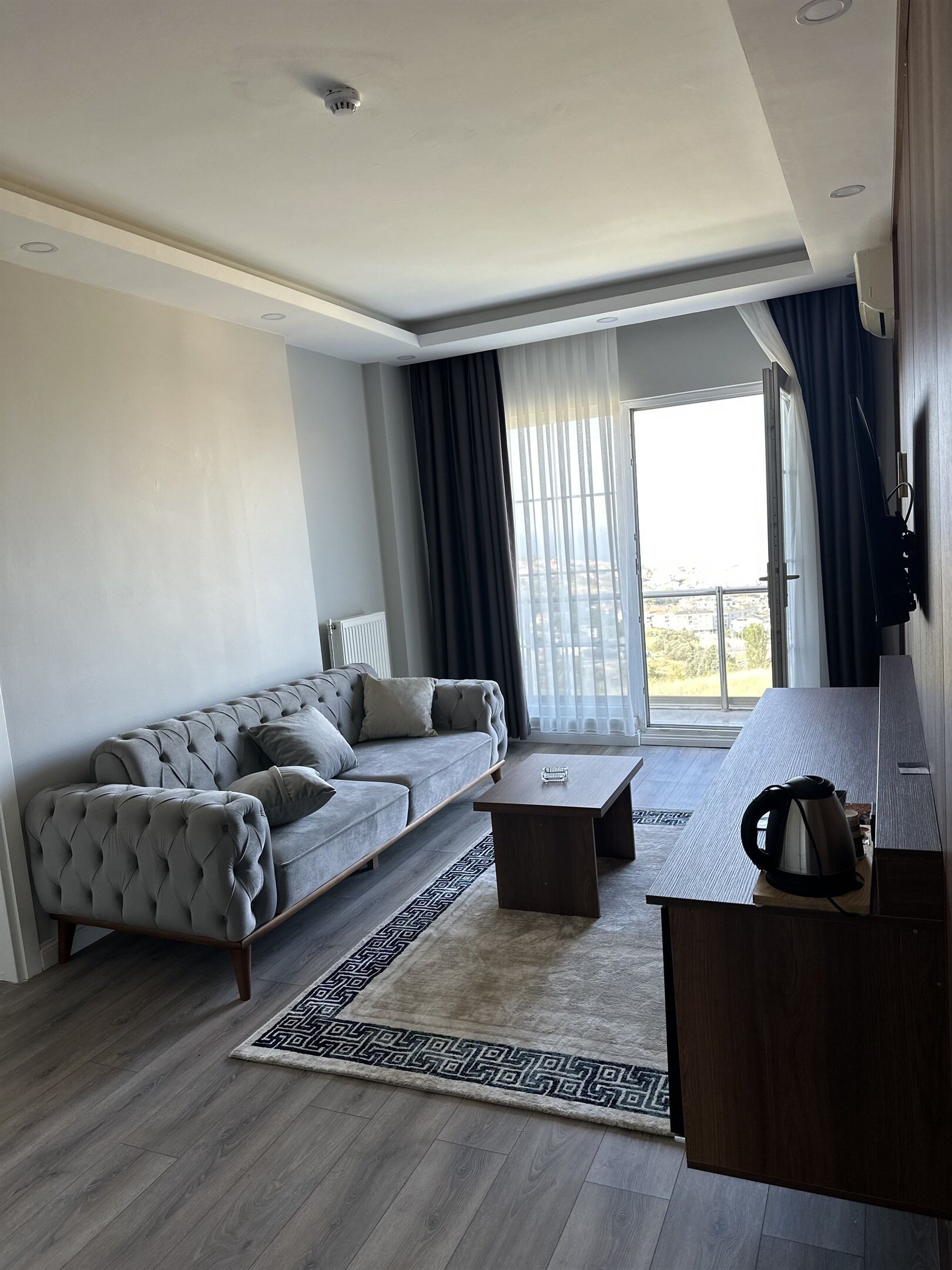Una sala de estar moderna con un sofá, una mesa de centro y vistas al exterior.