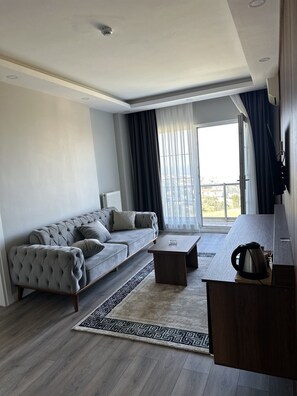 Una sala de estar moderna con un sofá, una mesa de centro y vistas al exterior.