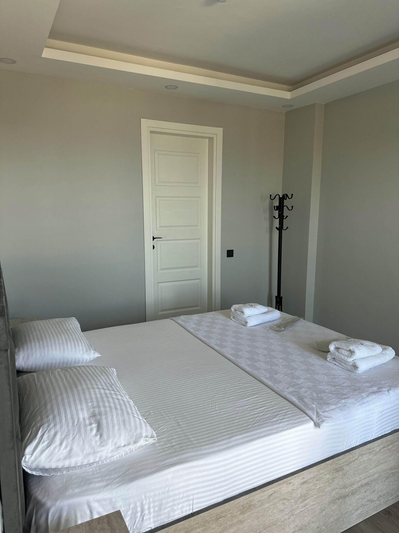 A double bed with two pillows and two folded towels.