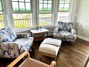 A room with a sofa, armchair, ottoman, and a small table with decorative items. - Ocean front Home with Private dock - Winter rental Available (Harpswell)