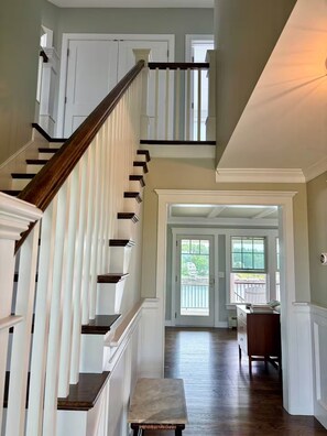 A multi-level interior with a wooden staircase, white walls, and a view through a glass door to an outdoor area. - Ocean front Home with Private dock - Winter rental Available (Harpswell)