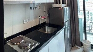 Eine moderne Küche mit schwarzer Arbeitsplatte, Spüle aus Edelstahl und weißen Schränken.