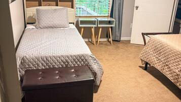 Un dormitorio con cama, escritorio y puerta.