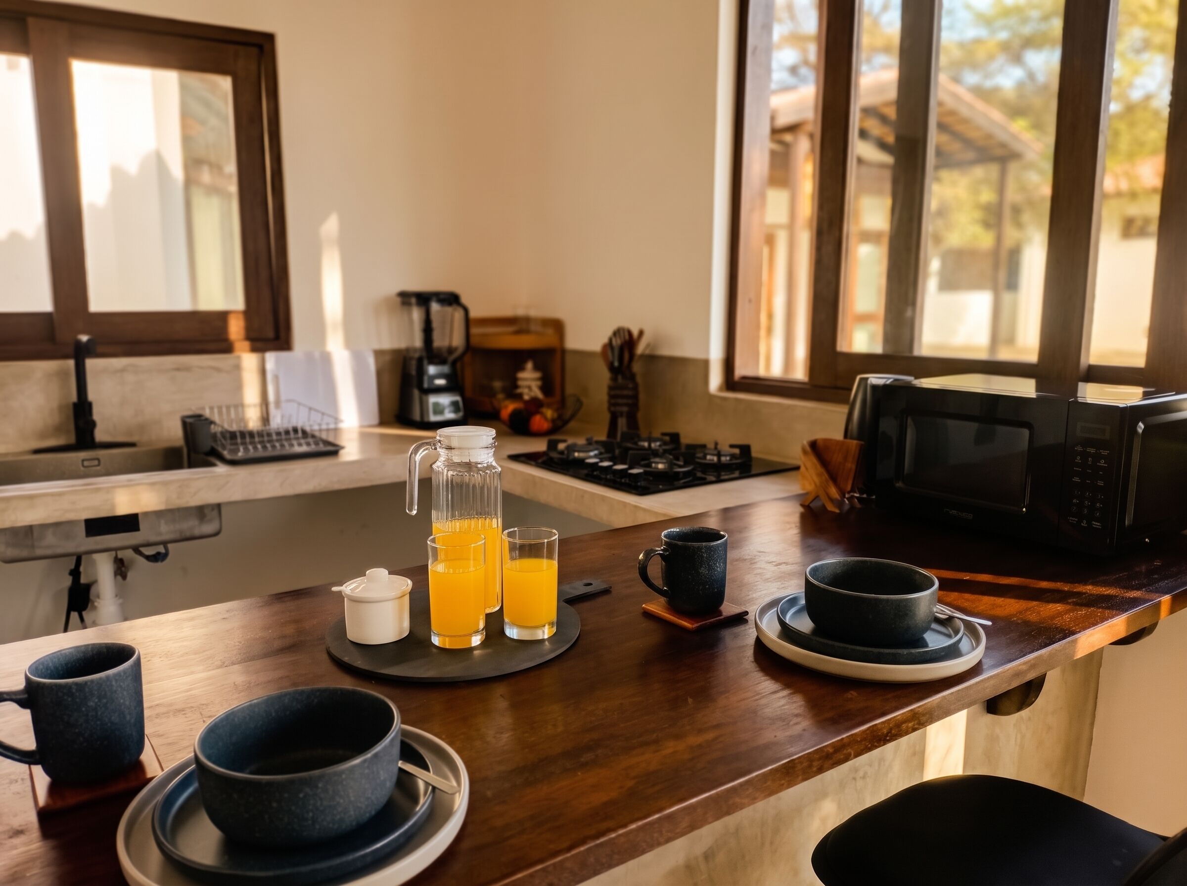 A kitchen counter with a coffee maker, a kettle, a microwave, and a fruit juicer.