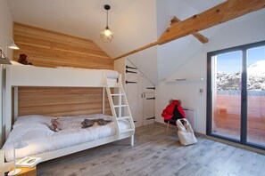 A room with a bunk bed, a ladder, a chair, and a large window with a view of mountains. - Chalet rénové à 150 m du télésiège | Vue montagne (Mont-de-Lans)