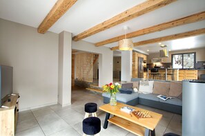 A modern living room with a sofa, a coffee table, and a chessboard. - Chalet rénové à 150 m du télésiège | Vue montagne (Mont-de-Lans)