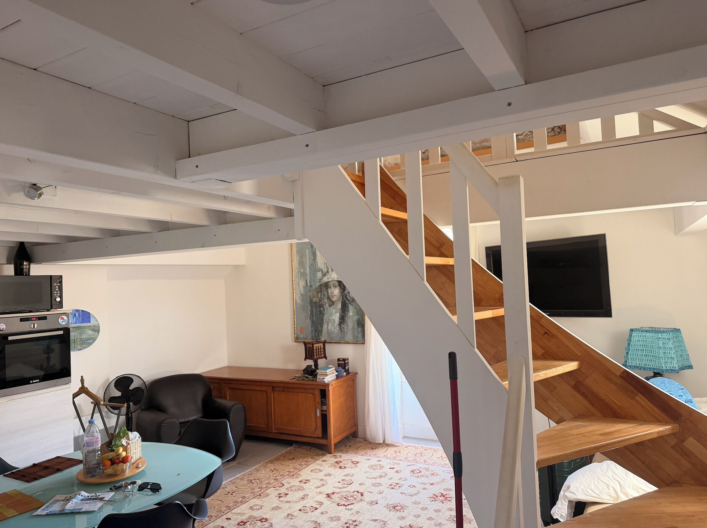A modern interior with a staircase, a dining area, and a kitchen.