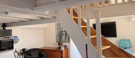 Un intérieur moderne comprenant un escalier, un coin repas et une cuisine.