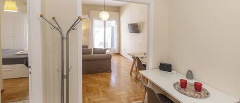 Una habitación de hotel con cama, escritorio, silla, mesa de comedor y televisión.