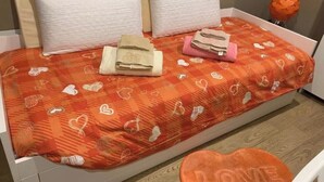 A bed with a patterned bedspread, pillows, and folded towels. - Casa Rosina, nestled in a typical neighborhood atmosphere with everything just a stone's throw away. (Palermo)