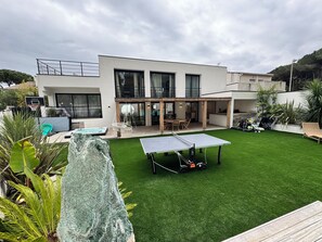 A modern house with a tennis court, a pool, and a patio area. - Villa near the beaches and all amenities (La Grande-Motte)
