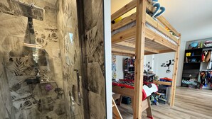 Ein Zimmer mit einem Holzbett und einem Kicker.