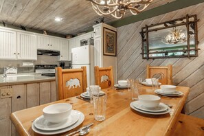 A dining area with a wooden table set for four, white plates, glasses, and cutlery. - Short Walk to Canyon 683 (Mammoth Lakes)