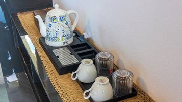 Een keukenhoek met een theeset, inclusief een theepot en kopjes, op een dienblad.