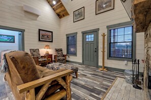 A cozy room with a wooden bench, a chair, a lamp, and a door with a window. - Cozy Cottage in the Foothills of Blue Ridge Mtns. (Clarkesville)